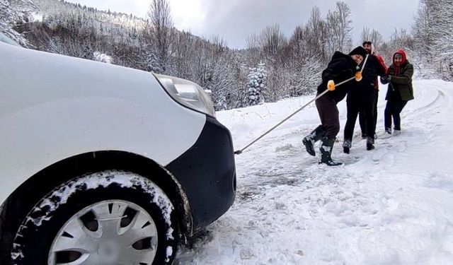 Aracı kurtarmak için her yolu deneyen köylülerin yardımına karla mücadele ekipleri yetişti